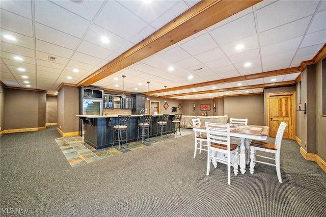 carpeted dining space featuring visible vents, baseboards, wet bar, recessed lighting, and a paneled ceiling