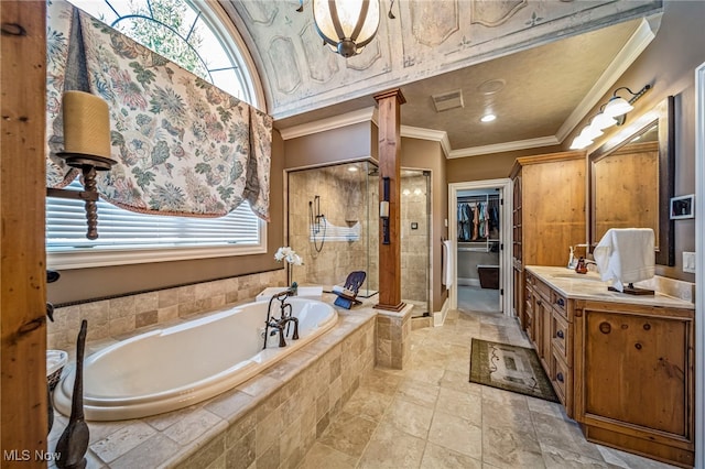 full bathroom featuring vanity, ornate columns, a shower stall, crown molding, and a bath