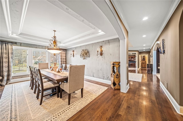 dining space featuring a tray ceiling, wood finished floors, recessed lighting, crown molding, and baseboards