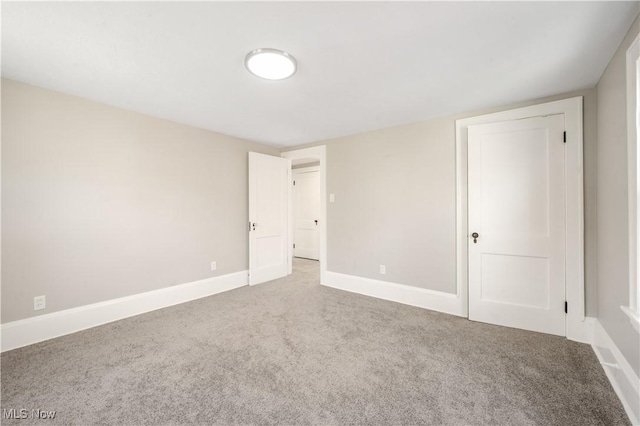 unfurnished room featuring baseboards and carpet flooring