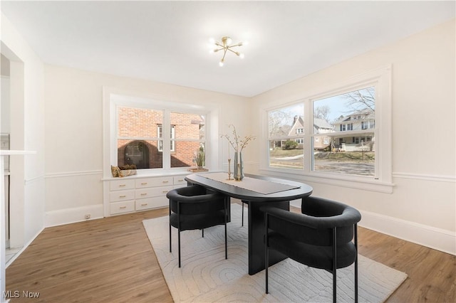 dining room featuring light wood-style flooring and baseboards