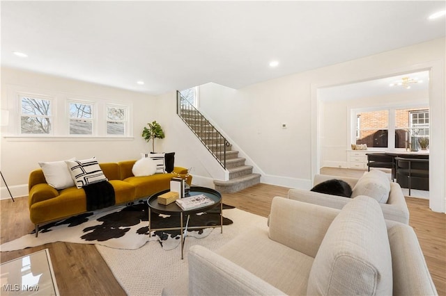 living room with plenty of natural light, stairs, and wood finished floors