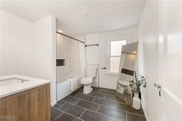 full bathroom with baseboards, toilet, shower / bath combo with shower curtain, tile patterned floors, and vanity