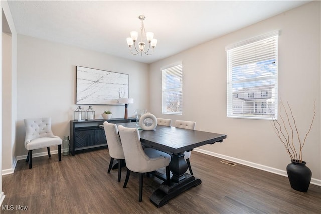 dining room with a wealth of natural light, a notable chandelier, dark wood finished floors, and baseboards