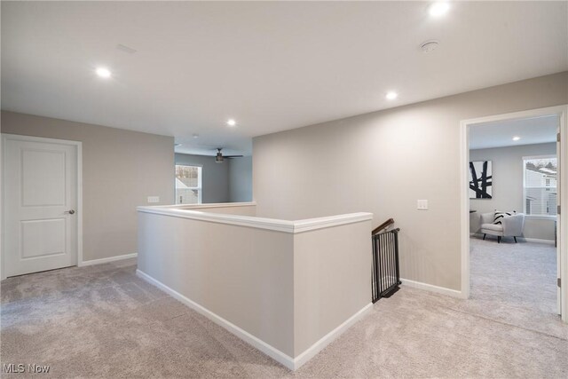 corridor with baseboards, an upstairs landing, carpet flooring, recessed lighting, and plenty of natural light