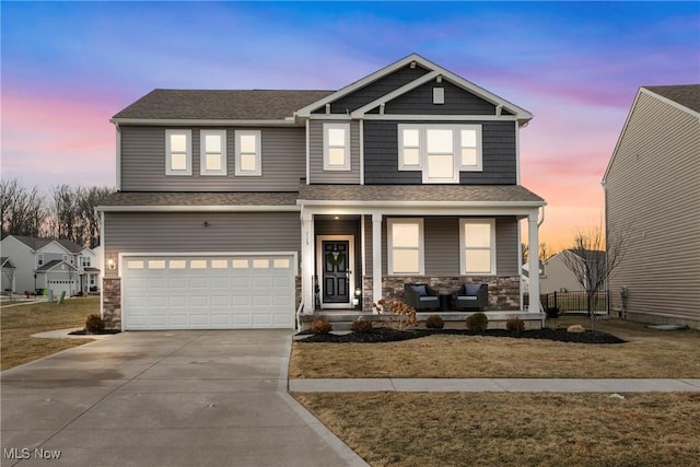 view of front facade featuring a porch, an attached garage, stone siding, and concrete driveway