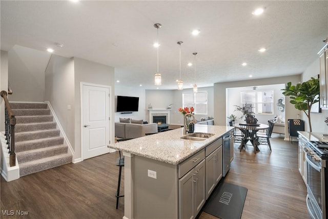 kitchen featuring a sink, dark wood finished floors, appliances with stainless steel finishes, and gray cabinetry