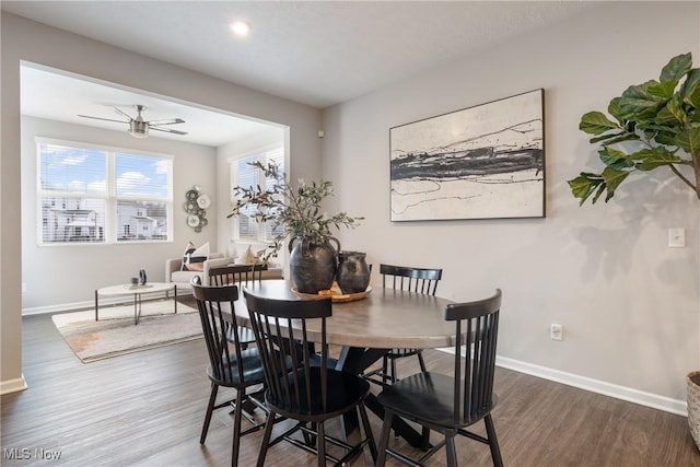 dining room with a ceiling fan, baseboards, and dark wood-style flooring