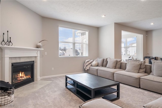 carpeted living area with plenty of natural light, a fireplace, baseboards, and a textured ceiling