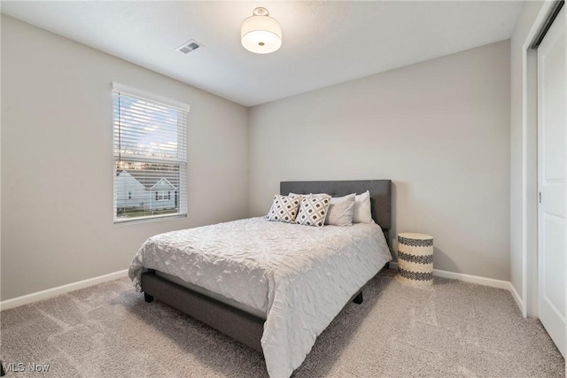 carpeted bedroom featuring a closet, visible vents, and baseboards