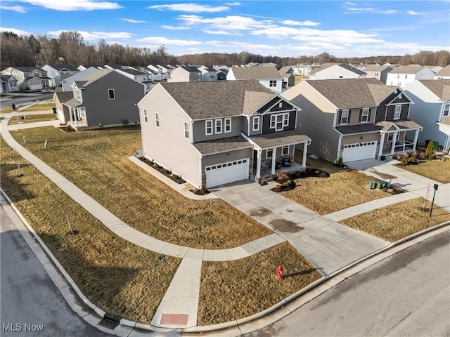 exterior space with a residential view, an attached garage, a shingled roof, and driveway