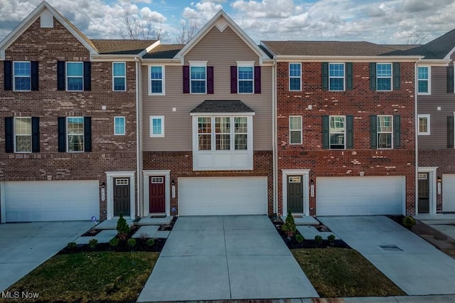 townhome / multi-family property with brick siding and an attached garage