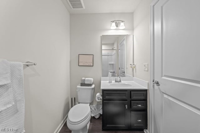 bathroom featuring vanity, toilet, baseboards, and visible vents