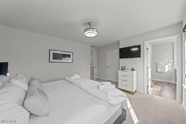 bedroom featuring light colored carpet and baseboards