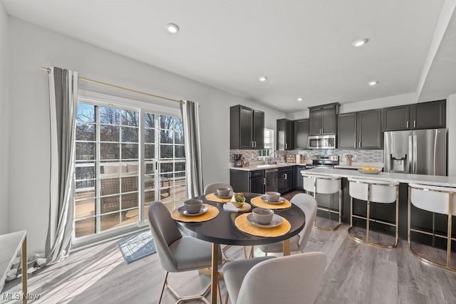 dining space featuring recessed lighting and light wood-style floors