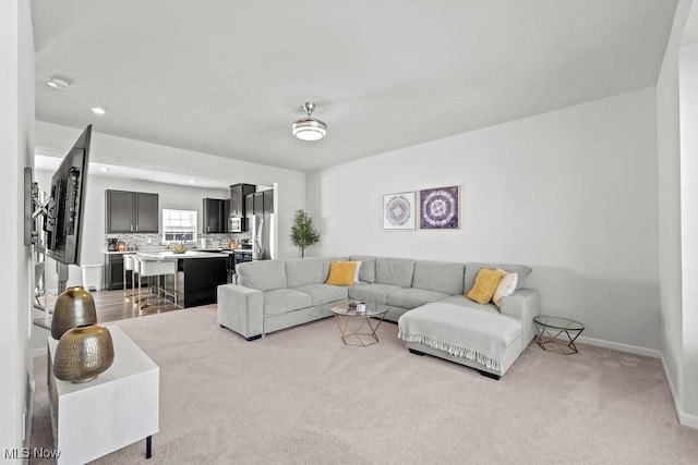 living room featuring light colored carpet and baseboards