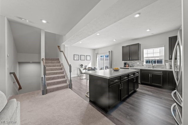 kitchen with decorative backsplash, light countertops, freestanding refrigerator, and wood finished floors