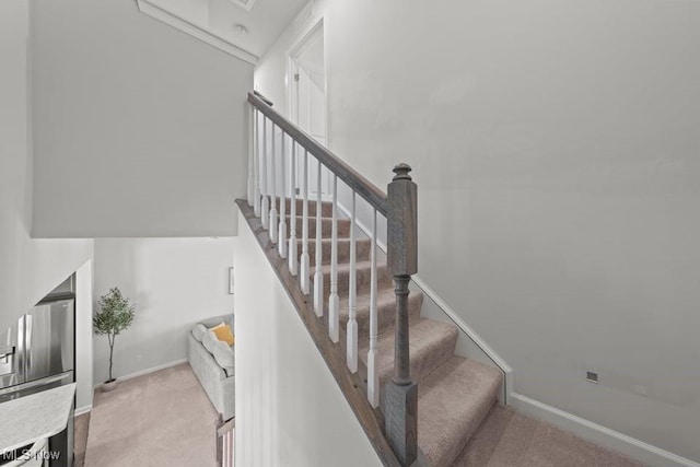 staircase featuring baseboards and carpet floors