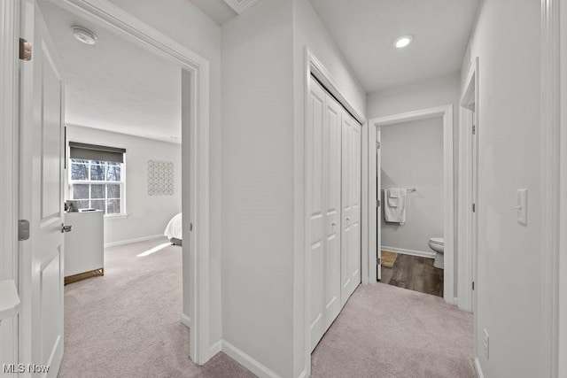 corridor with recessed lighting, baseboards, and light colored carpet