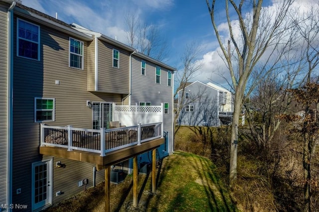 back of property with central AC unit and a lawn