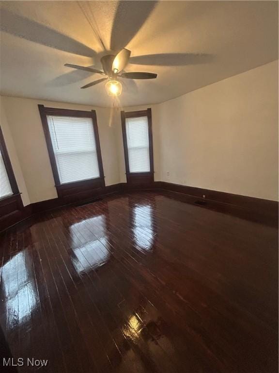 spare room with hardwood / wood-style floors, baseboards, and ceiling fan