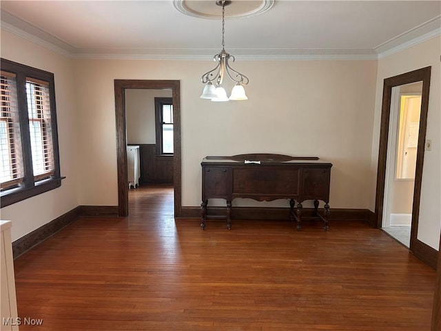 unfurnished dining area featuring a wealth of natural light, ornamental molding, and wood finished floors