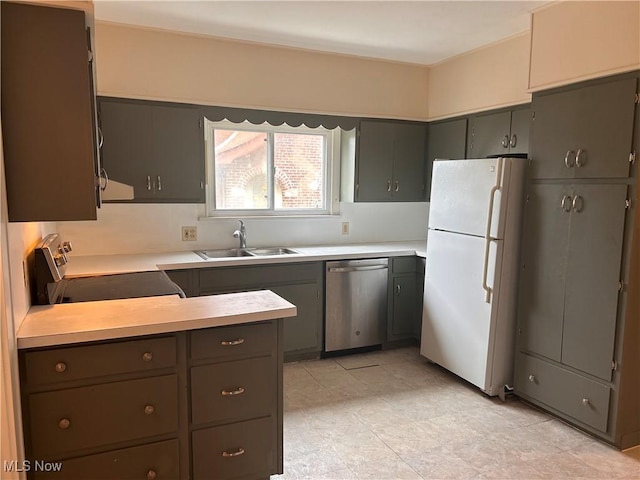 kitchen featuring a sink, freestanding refrigerator, light countertops, range, and dishwasher