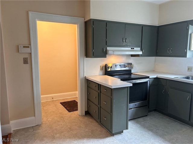 kitchen with under cabinet range hood, gray cabinetry, light countertops, and stainless steel range with electric cooktop