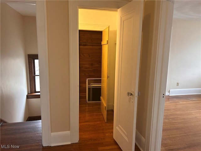 hallway featuring wood finished floors and baseboards