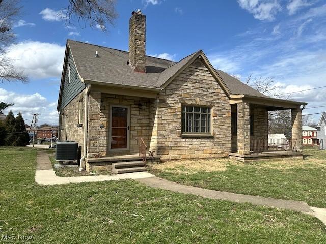 1119 Abbey Pl, Zanesville, OH 43701 - rear view of property with a lawn, stone siding, a porch, central AC, and a chimney