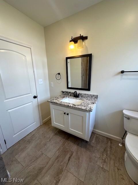 1119 Abbey Pl, Zanesville, OH 43701 - bathroom featuring vanity, toilet, wood finished floors, and baseboards