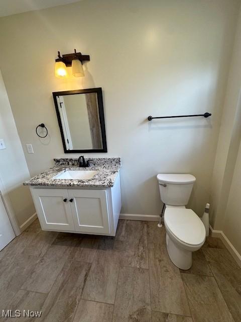 1119 Abbey Pl, Zanesville, OH 43701 - bathroom featuring toilet, vanity, baseboards, and wood finished floors