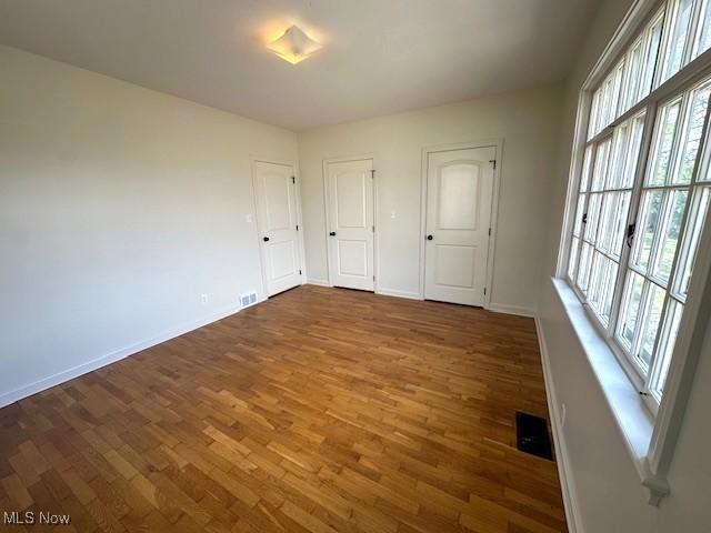 1119 Abbey Pl, Zanesville, OH 43701 - unfurnished bedroom with multiple windows, wood finished floors, and baseboards