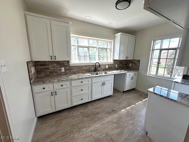 1119 Abbey Pl, Zanesville, OH 43701 - kitchen featuring light stone countertops, white cabinetry, and a sink