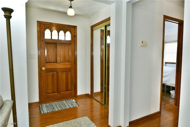 foyer with baseboards and wood finished floors