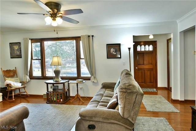 living room featuring ornamental molding, baseboards, a ceiling fan, and wood finished floors