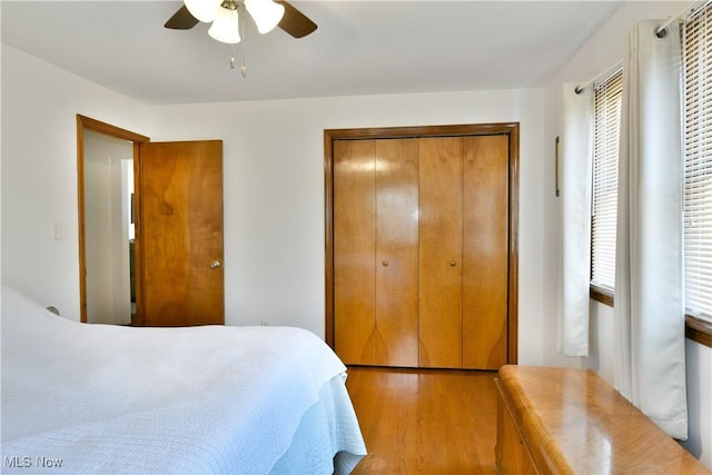 bedroom featuring light wood-type flooring, a closet, and a ceiling fan