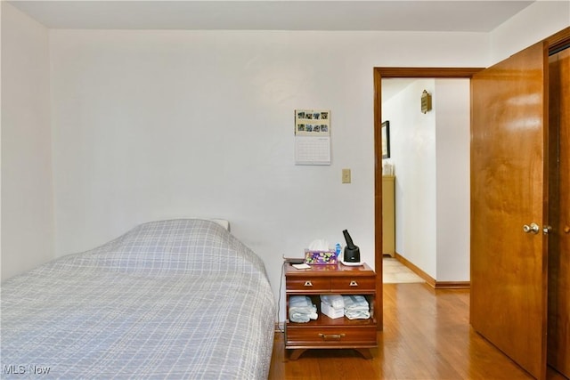 bedroom featuring baseboards and wood finished floors