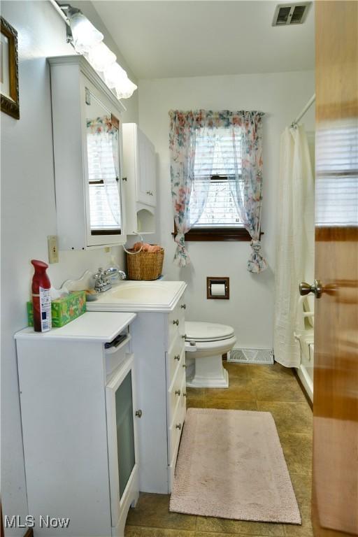 bathroom with visible vents, vanity, toilet, and a shower with shower curtain