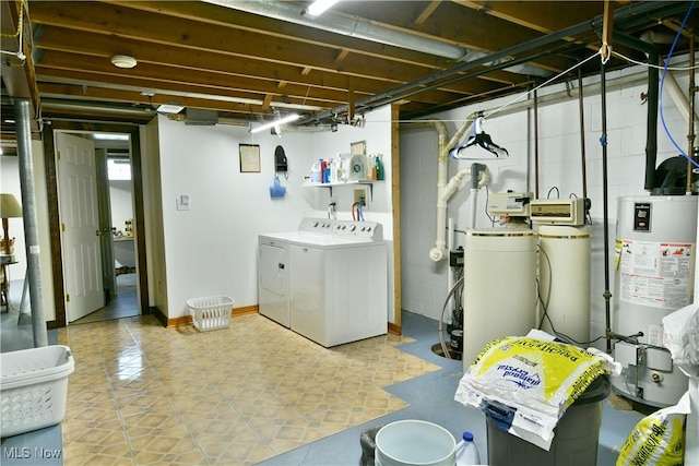 unfinished basement with gas water heater, baseboards, and washing machine and clothes dryer