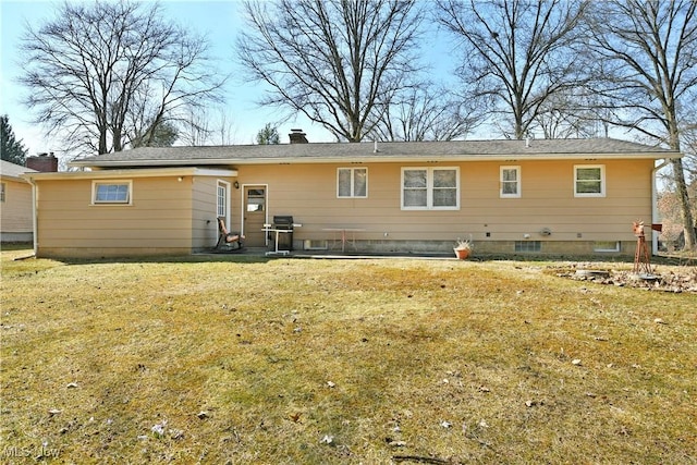 rear view of house with a yard and a chimney