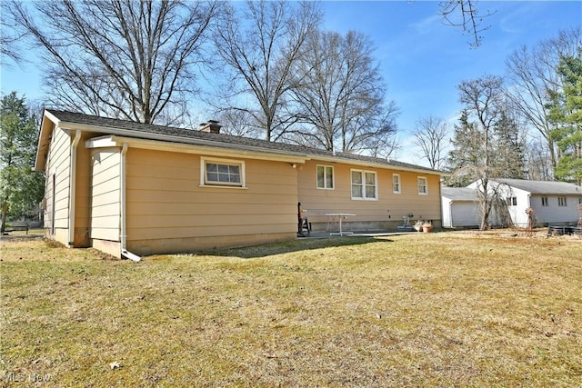 rear view of property featuring a lawn and a chimney