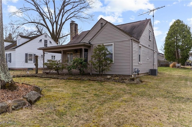 exterior space with a yard, cooling unit, and a chimney