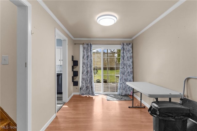 interior space with crown molding, baseboards, and wood finished floors