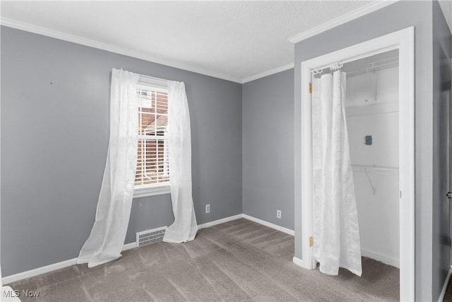 unfurnished bedroom featuring visible vents, baseboards, carpet, and ornamental molding