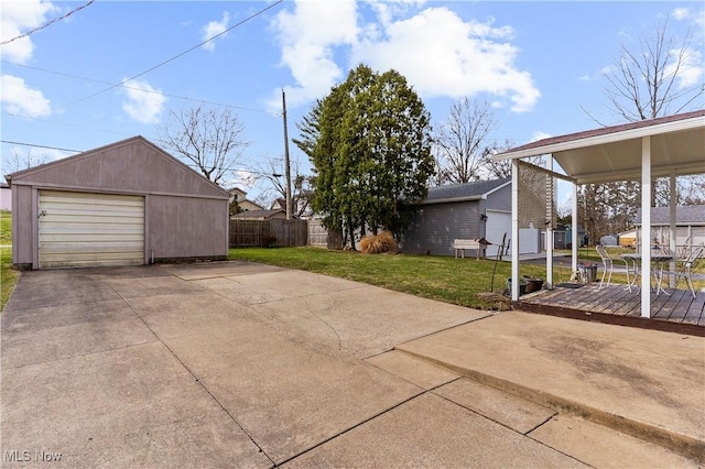 exterior space with an outbuilding, driveway, a detached garage, and fence