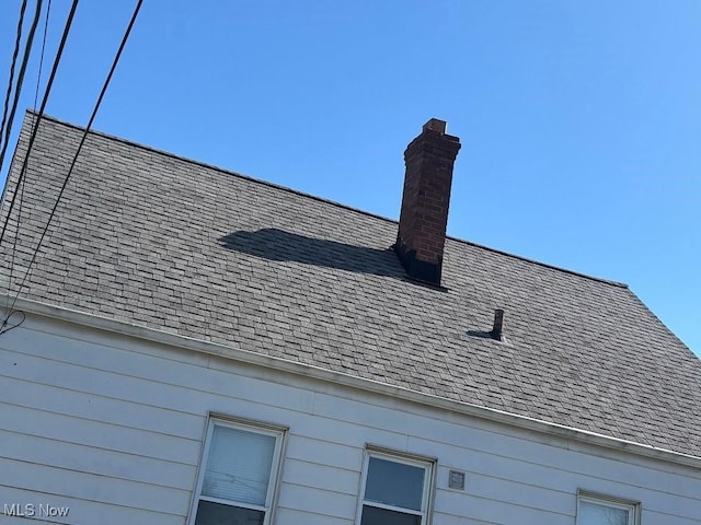 details with a chimney and a shingled roof