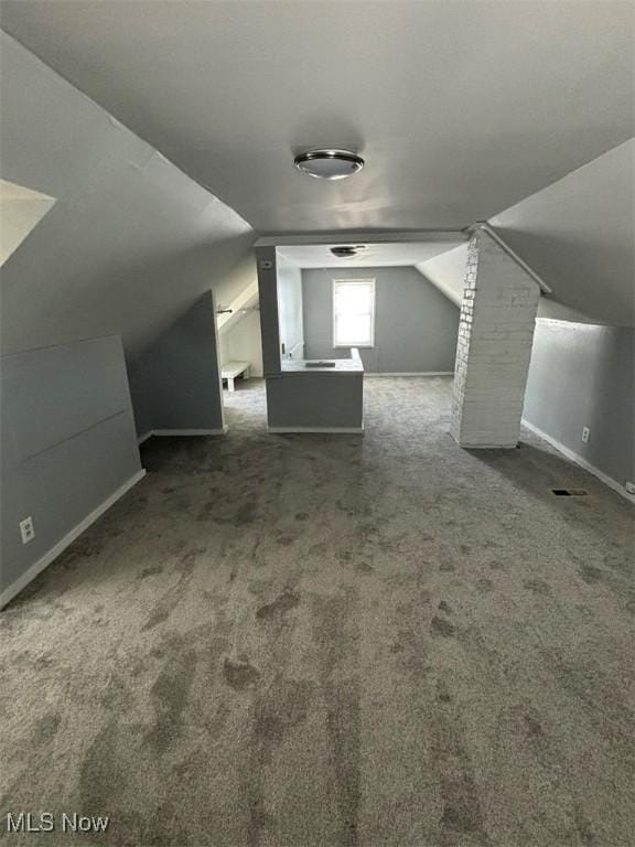 additional living space with lofted ceiling and carpet