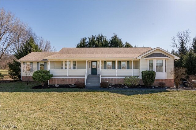 ranch-style home with crawl space, roof with shingles, covered porch, and a front lawn