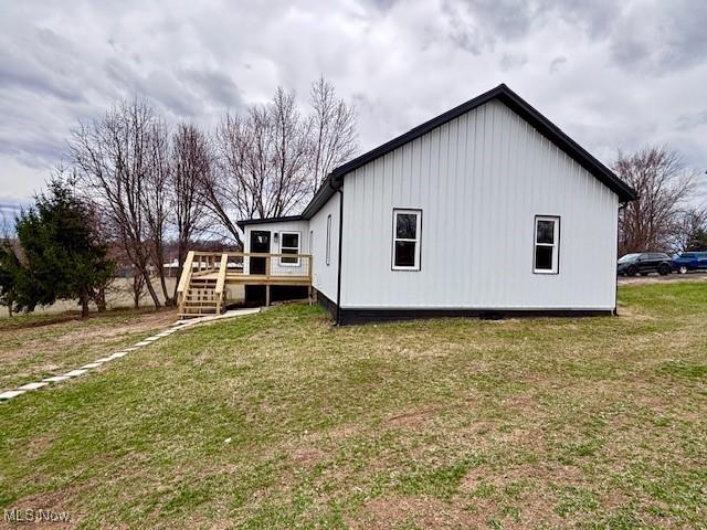 view of property exterior featuring a yard and a wooden deck